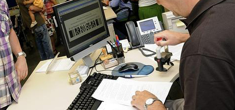 Empleado pblico sellando un documento en el registro general